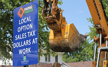 Construction equipment and Paving for Progress sign