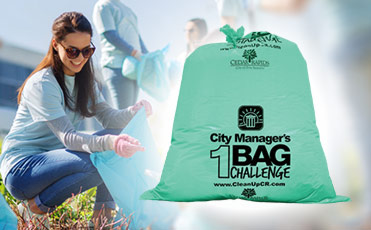 A group collects litter using the City Manager's 1-Bag Challenge mint green bags