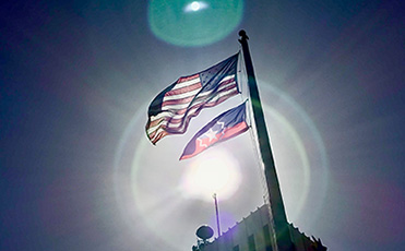 A Juneteenth flag flies beneath the American flag on the City Hall flag pole.